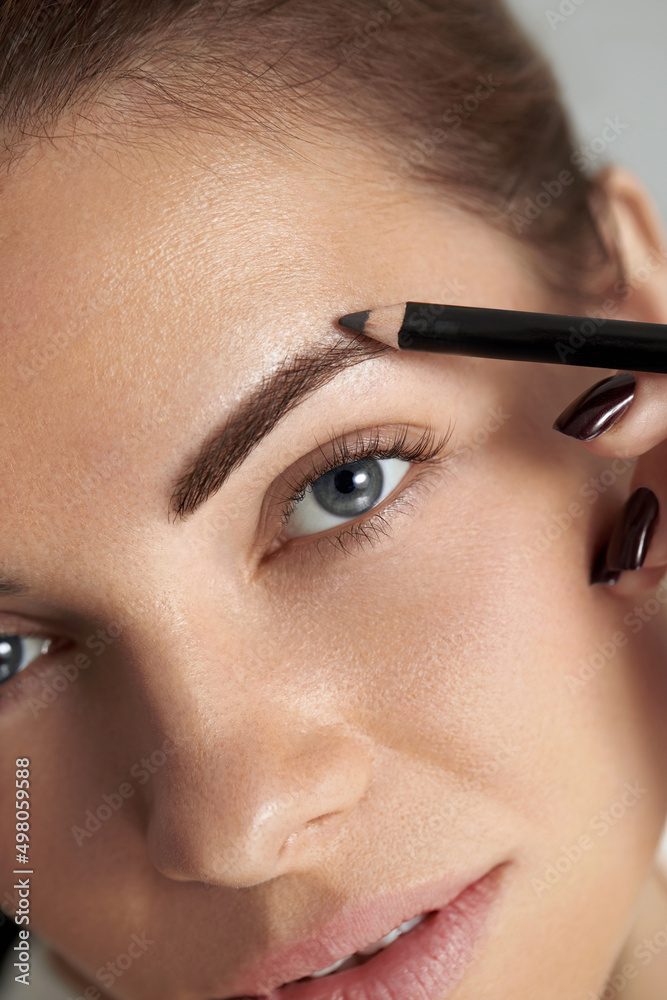 Eyebrow makeup. Beauty model shaping brows with brow pencil closeup. Beautiful sexy woman with eyebrows correction.
