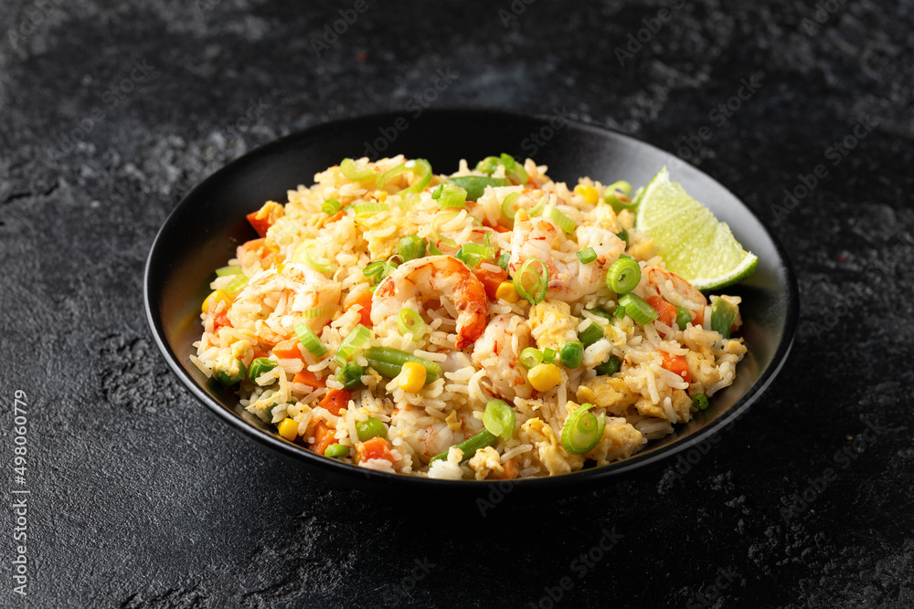Prawn fried rice with eggs and vegetables in black bowl. Healthy asian food. Prawn fried rice with eggs and vegetables in black bowl. Healthy asian food.