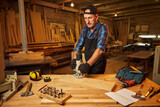 Senior Professional carpenter in uniform working of manual milling machine in the carpentry workshop