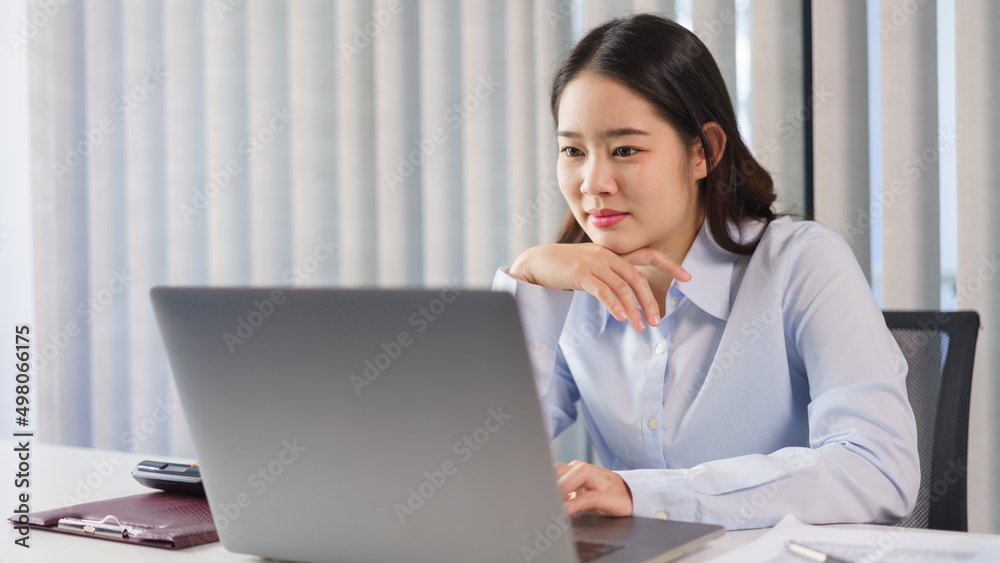 Business concept, Businesswoman thoughtful about new project while reading marketing data on laptop Business concept, Businesswoman thoughtful about new project while reading marketing data on laptop
