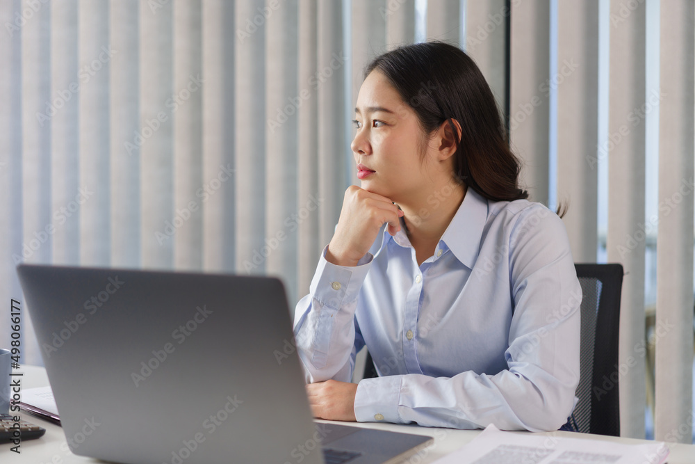 Business concept, Businesswoman sit to thoughtful about new project while looking out the window Business concept, Businesswoman sit to thoughtful about new project while looking out the window
