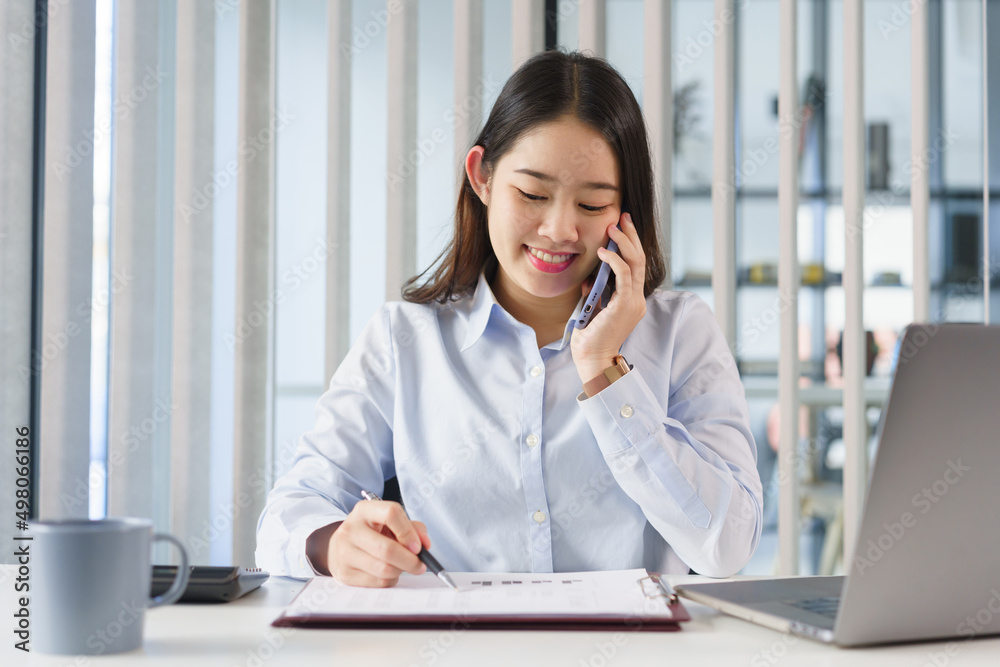 Business concept, Businesswoman talking with partners on phone to checking information on document