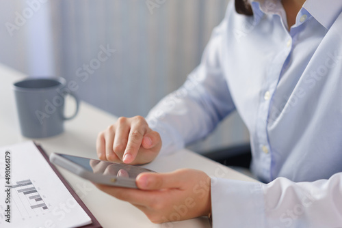 Business concept  Businesswoman checking marketing data on smartphone to analyze cost of project