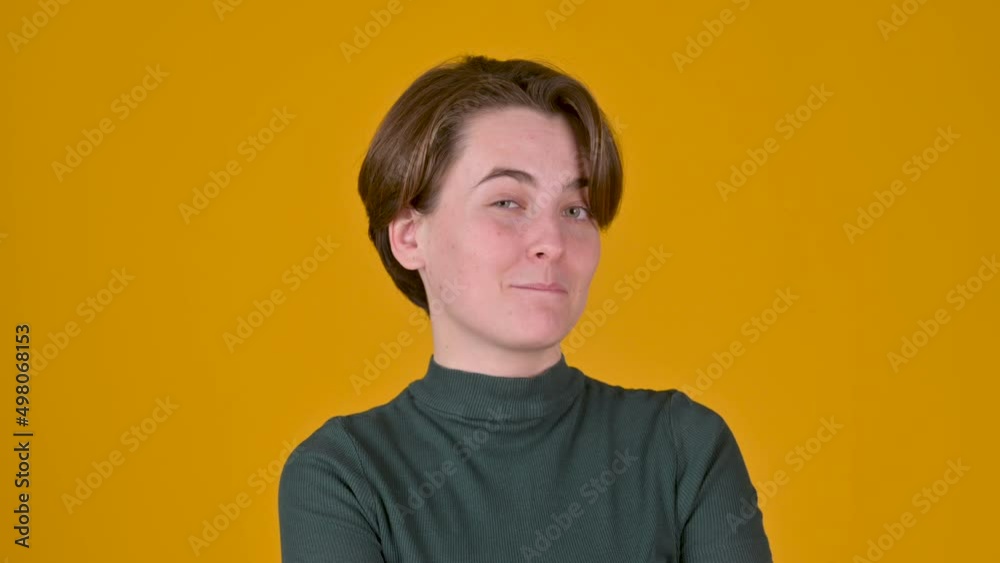 Portrait of young playful girl smiling and winking to camera over yellow studio background. People sincere emotions lifestyle Portrait of young playful girl smiling and winking to camera over yellow studio background. People sincere emotions lifestyle