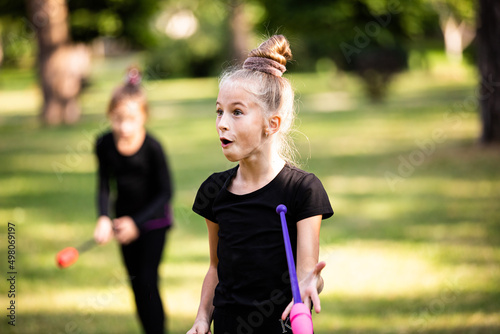 Girl surprised by something on rhythmic gymnastics training in summer outdoors