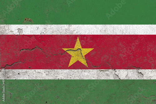 Suriname flag on a damaged old concrete wall surface