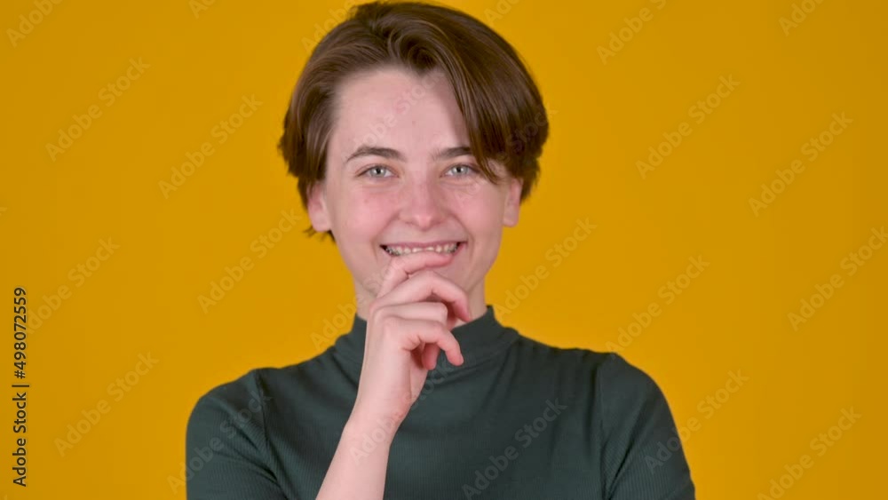 Women's secret. Young attractive girl smiling and holding finger on lips making silence gesture Women's secret. Young attractive girl smiling and holding finger on lips making silence gesture