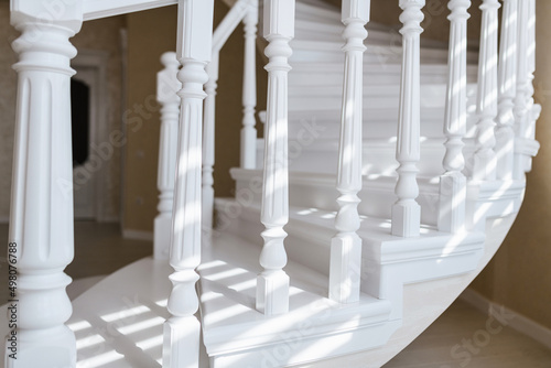 white stairs made of natural wood and railings in a new bright house