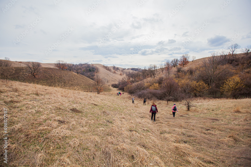 Countryside Nature Landscape. Group of Hikers Walking at Desert-Like Relief. Hills and Fields, Pasture Area, Early Spring Seasons. Dry Grassy Vegetation. Zagacija Hills. Deliblato Sands. Serbia. 