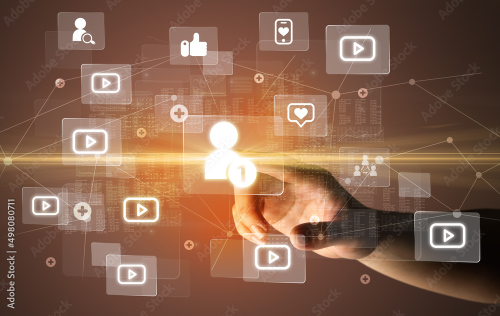 Hand pressing social media multimedia application screen with media icons on futuristic concept Hand pressing social media multimedia application screen with media icons on futuristic concept