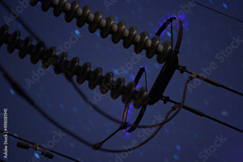 Corona discharge on high power transmission line on a night sky background