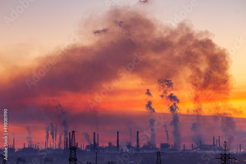 фотографія Dramatic industrial landscape with black smoke from the plant chimneys in the sk