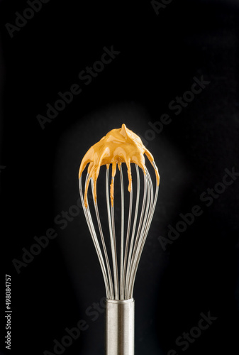 whisk with dalgona foam, preparation of whipped instant coffee cream, black background