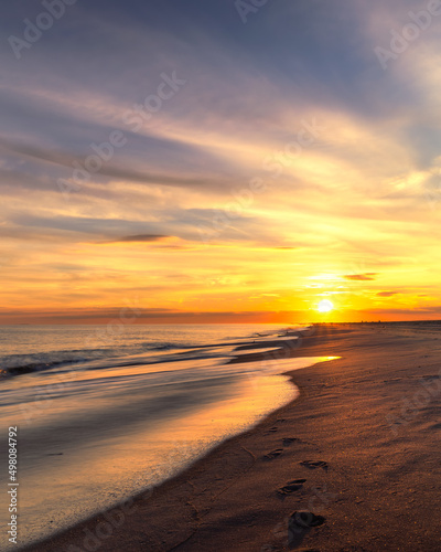 Footprints leading off into the sunset along a beautiful beach. Long Island New York