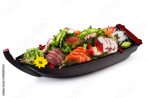 Combo Sushi sashimi: salmon, tuna, shrimp, nishin octopus, red caviar with vegetables in a wooden boat with ice isolated on white background
