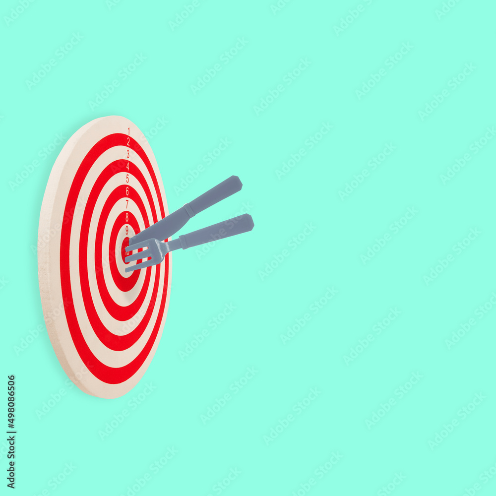 Red white target with fork and knife hit in center. Bullseye good food goal concept. Cuisine idea Red white target with fork and knife hit in center. Bullseye good food goal concept. Cuisine idea