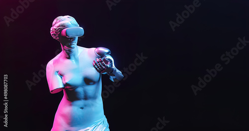Statue of robot woman with virtual reality glasses in neon light on black background