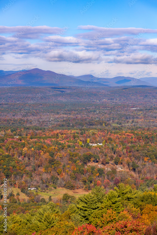 Small white cottage in the middle of colorful fall foliage. New Paltz, New York