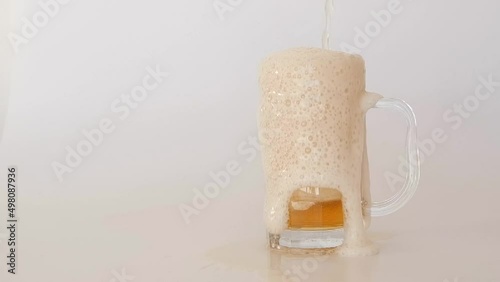 Beer foam overflowing from glass