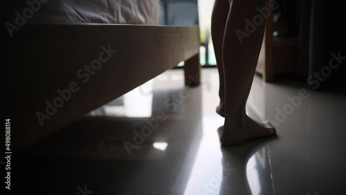 Close-up footage of feet. Woman getting out of bed in the morning