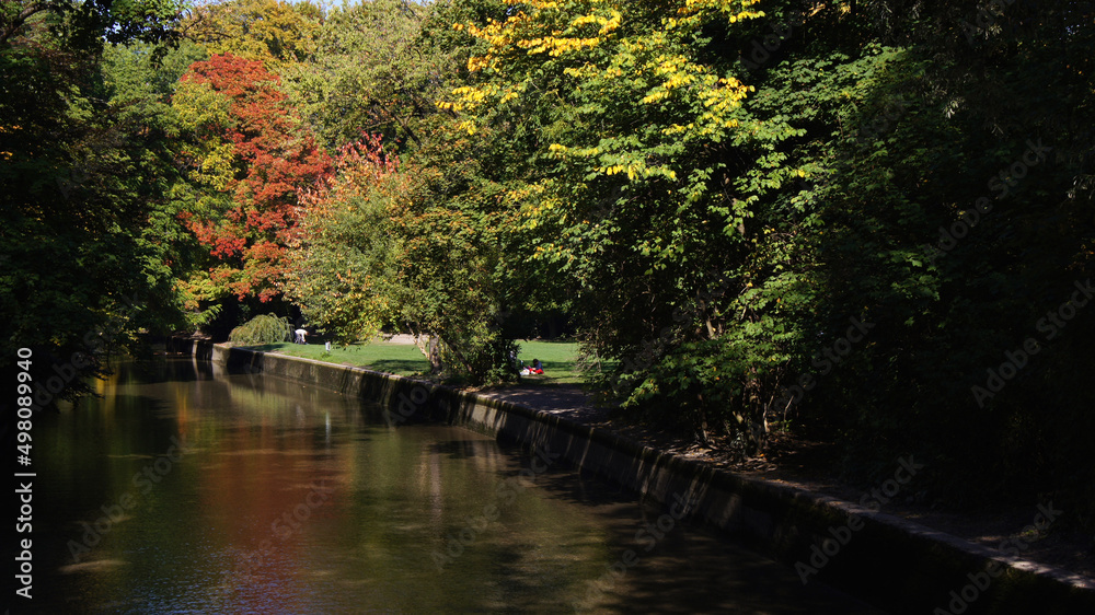 MUNICH, GERMANY - OCTOBER 12, 2015: Beautiful autumn day with Indian Summer coloring of trees in English Garden of Munich MUNICH, GERMANY - OCTOBER 12, 2015: Beautiful autumn day with Indian Summer coloring of trees in English Garden of Munich