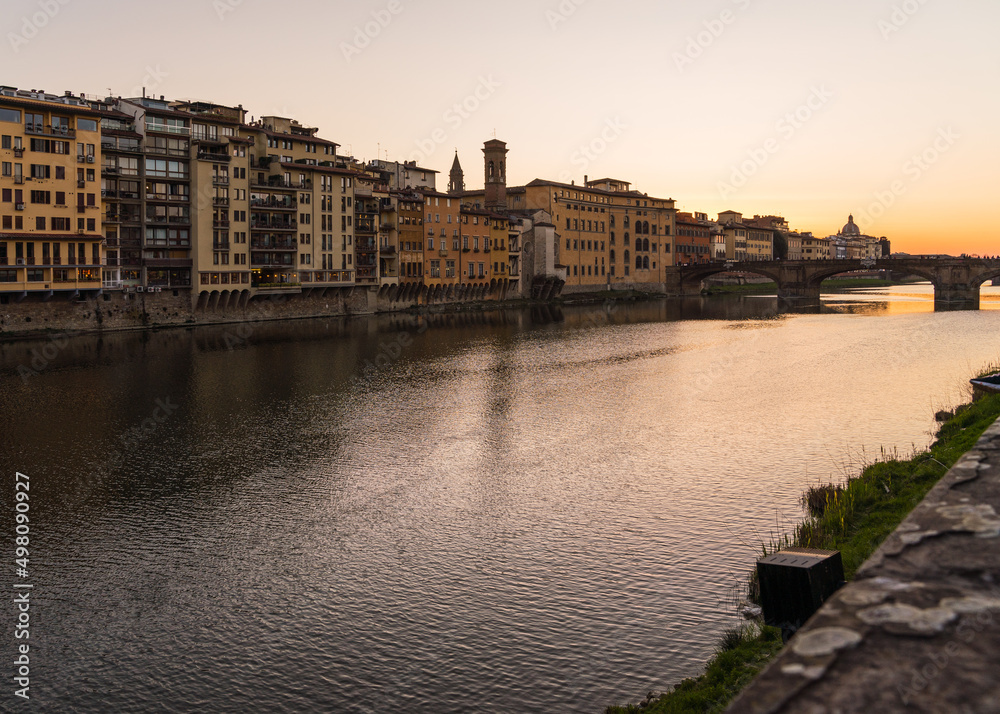 View of the Ponte Vecchio and sunset over the Arno river 