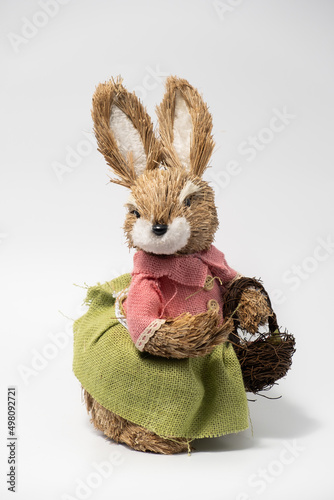 Easter Decorations Hare Rabbit of straw. Easter toy rabbit made of straw with a basket isolated on a white background