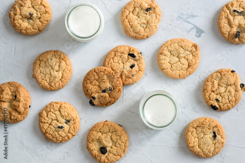 Cookies with chocolate and milk in a glass in the form of a pattern on a light table. An idea for a children's breakfast or snack. Flat lay, top view.