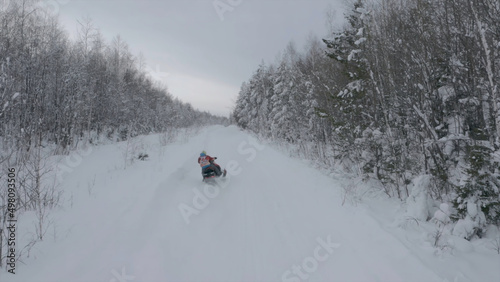 Snowmobile on winter forest highway. Clip. Beautiful winter road for extreme snowmobile driving. Extreme sports in winter
