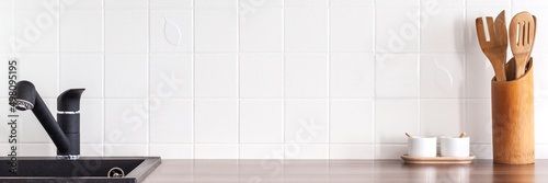 Industrial kitchen. White ceramic tiles as copy space. Black kitchen faucet. Banner. Panorama.