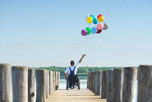 Fotografie Disabled man sitting in wheelchair showing freedom.