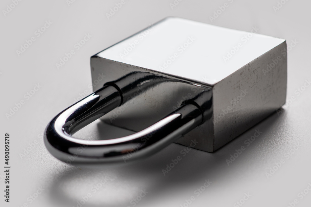 Locked silver padlock on a gray background.