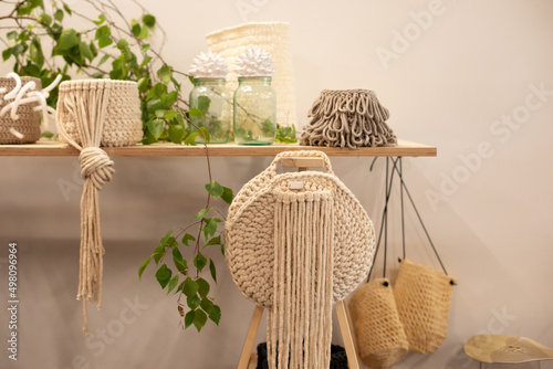 Handmade natural jute knit shopping bag, scandinavian style shopper, sustainable fashion accessories. Cozy details interior decoration at room. Knitted beige baskets on wooden table. Handmade	