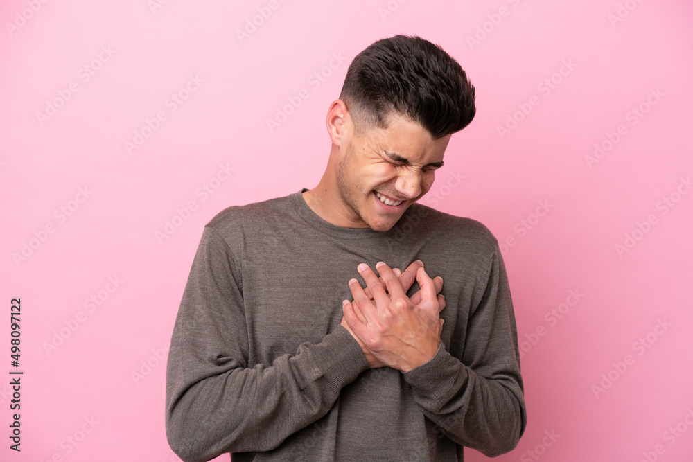 Young caucasian man isolated on pink background having a pain in the heart Young caucasian man isolated on pink background having a pain in the heart