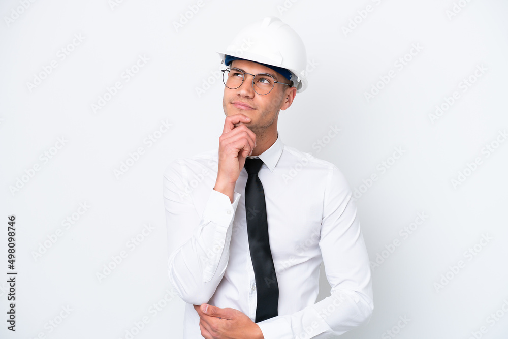 Young architect caucasian man with helmet and holding blueprints isolated on white background and looking up Young architect caucasian man with helmet and holding blueprints isolated on white background and looking up