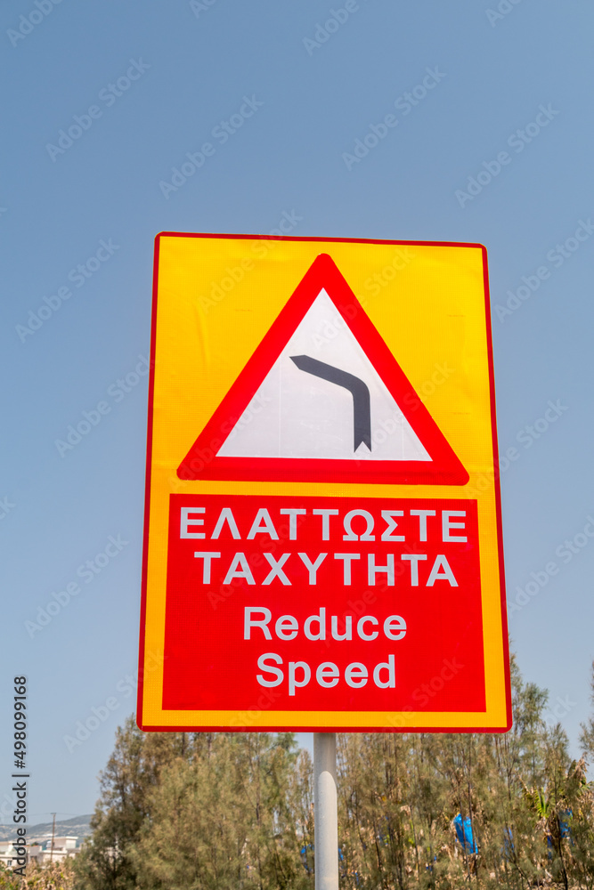 left-sharp-turn-warning-reduce-speed-sign-in-english-and-greek