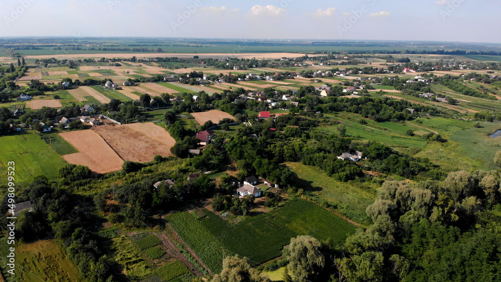 Beautiful Ukrainian landscape. Village among sown fields and gardens. Aerial view
