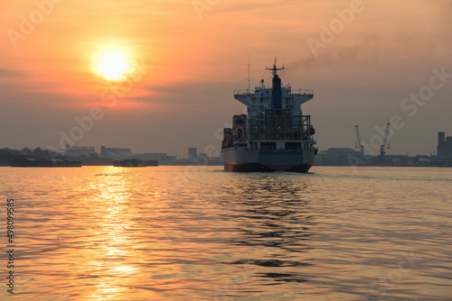 container cargo ship sail over Chao Phraya river at sunrise in Bangkok