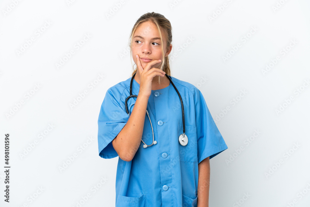 Little caucasian girl disguised as surgeon isolated on white background having doubts and with confuse face expression Little caucasian girl disguised as surgeon isolated on white background having doubts and with confuse face expression