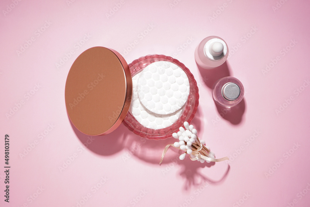 Spa concept. Cotton pads, cotton buds and cosmetic on a pink background. Top view. Spa concept. Cotton pads, cotton buds and cosmetic on a pink background. Top view.