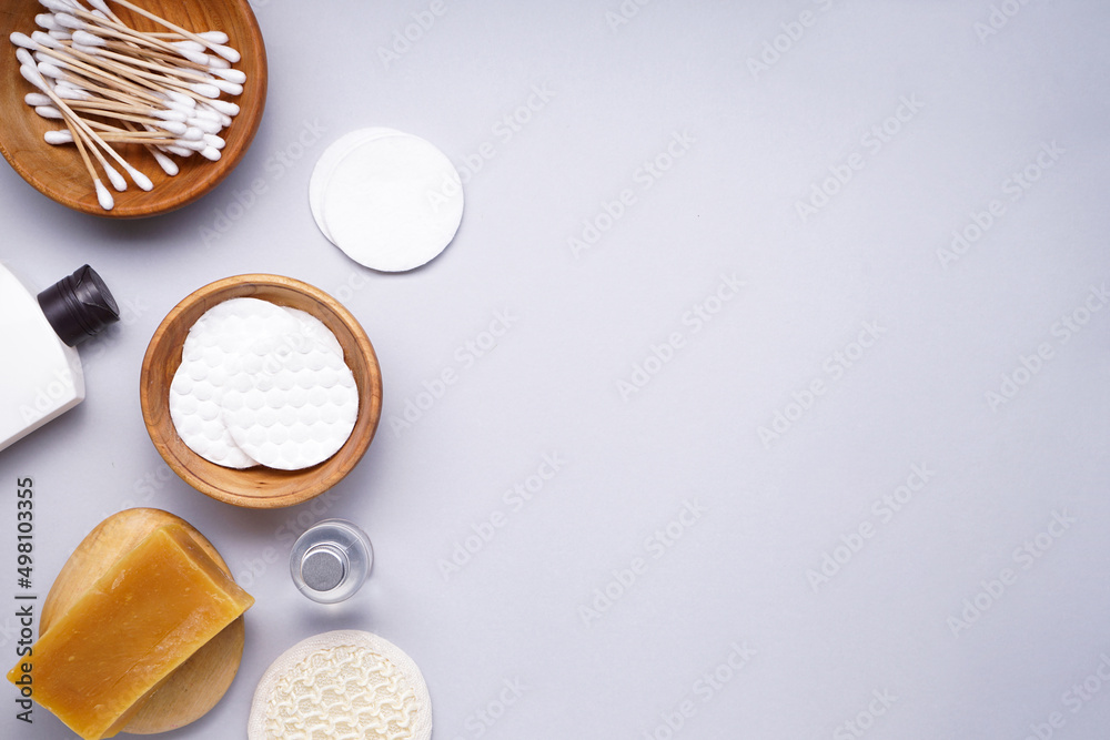 Spa concept. Cotton pads and personal care products on a gray background, space for text. Top view. Spa concept. Cotton pads and personal care products on a gray background, space for text. Top view.