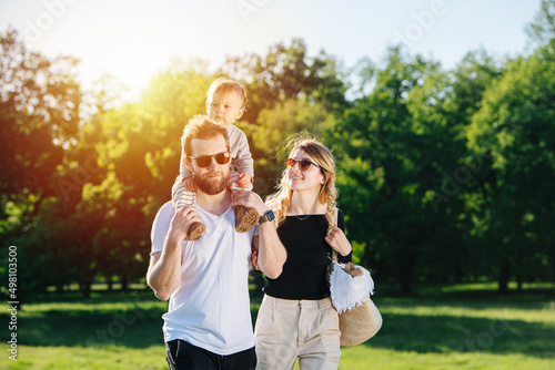 Lovely young family walking on a spring grass field in a countryside