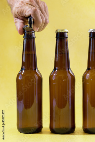 Waiter opening beer bottle with bottle opener