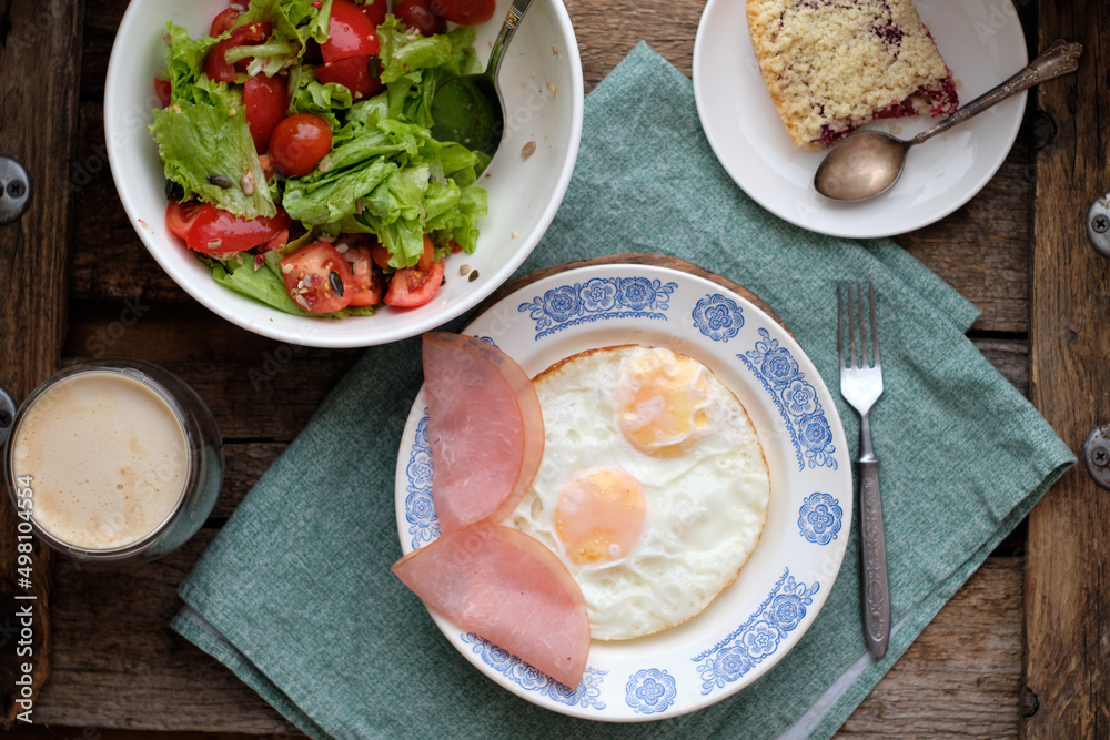 Breakfast. Salad with tomatoes and lettuce, scrambled eggs with bacon and a piece of crumble Breakfast. Salad with tomatoes and lettuce, scrambled eggs with bacon and a piece of crumble