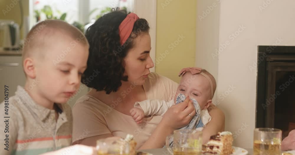 Tea party in the family circle. Mom gives the child to try a gluten-free cake. Tea party in the family circle. Mom gives the child to try a gluten-free cake.