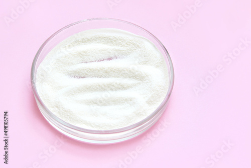 Collagen white powder. Pastel color background. Health product. Woman cosmetics concept. Sport supplement. Skincare cosmetics. Pink monochrome. Cream smear.