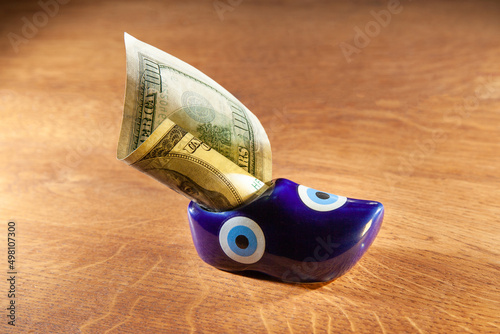 A rolled up US hundred dollar bill inserted into a toy shoe