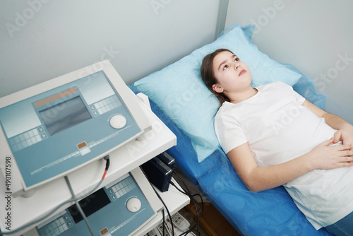 Girl having magnetic therapy procedure in clinic