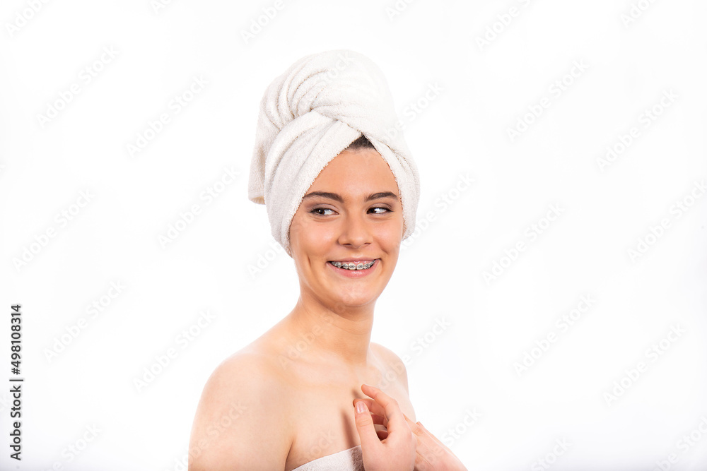 Portrait of beautiful teenage girl. Beautiful girl with a towel is smiling and showing the dental appliance. Portrait of beautiful teenage girl. Beautiful girl with a towel is smiling and showing the dental appliance.
