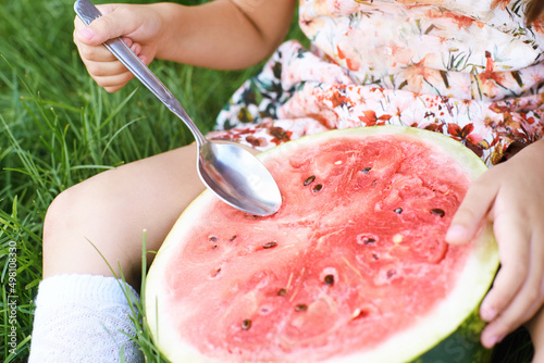 Funny female kid with watermelon slice. Summer child picnic. Kindergarden snack. Sweet natureal food. Red berry. Holding juicy vegetarian product photo